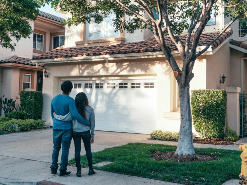 ​A couple standing in front of their house.
