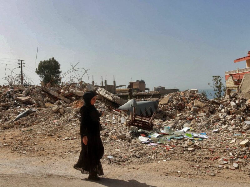 ​A Lebanese woman walks past rubble of a building that was hit by an overnight Israeli strike in the southern Lebanese village of Naqoura, March 28, 2024.