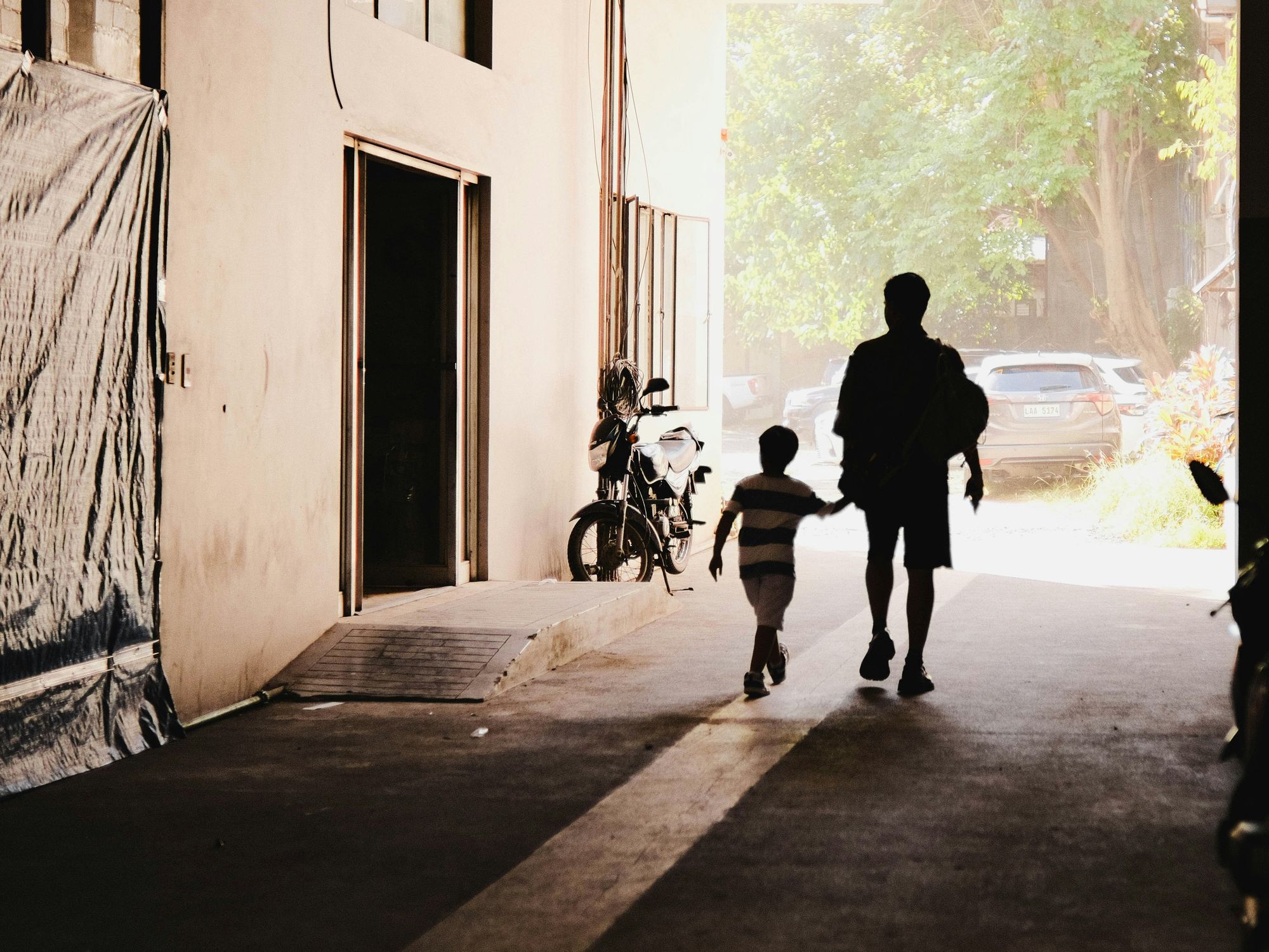 ​A man and child walking along the street in Davao city.