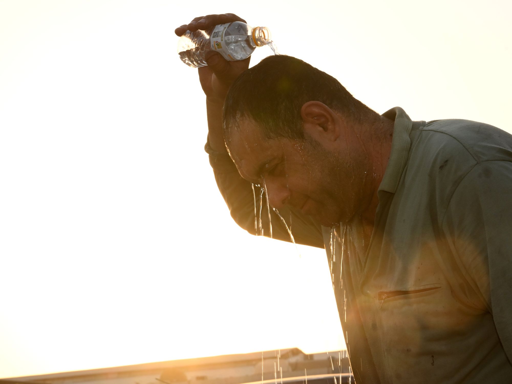 ​A man pours water on his head during a heatwave in Kuwait city.