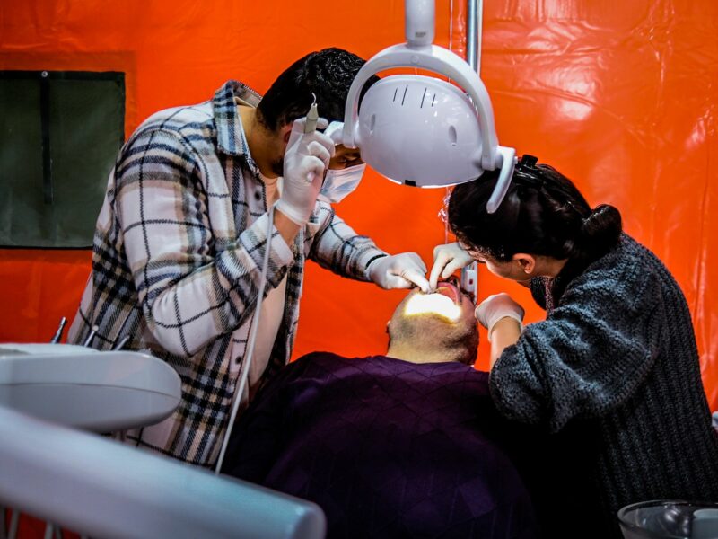 ​A man receives treatment in a dentist's tent.