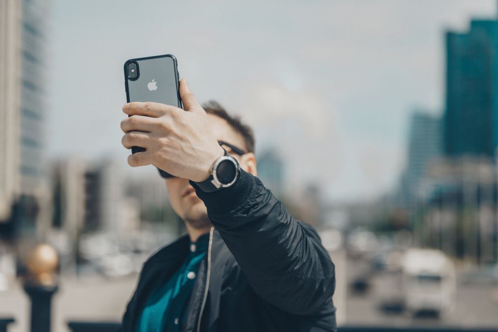 ​A man taking a selfie in the street.