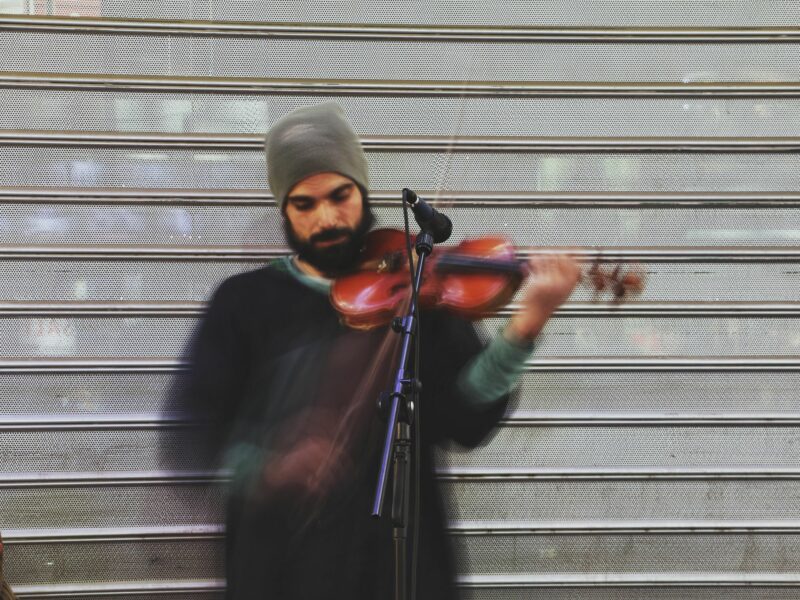 ​A man with a beanie playing the violon in Tehran, Iran