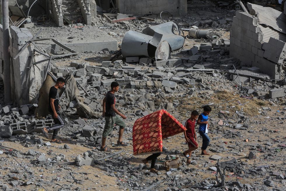 ​A Palestine family carries their valuables after wide spread Israeli bombing.