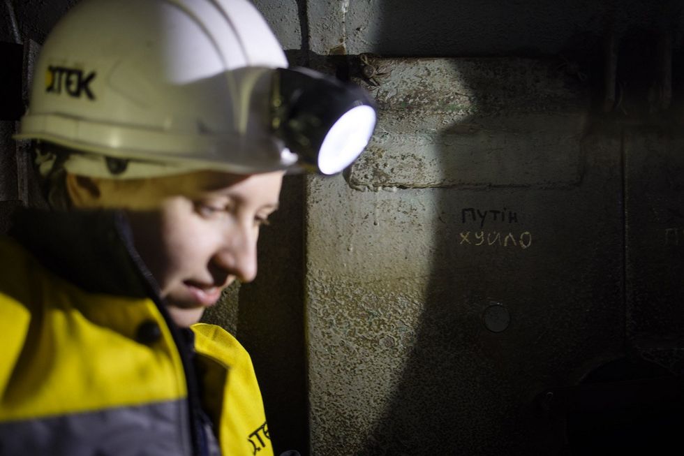 ​A photo of a woman with a miner helmet and light.