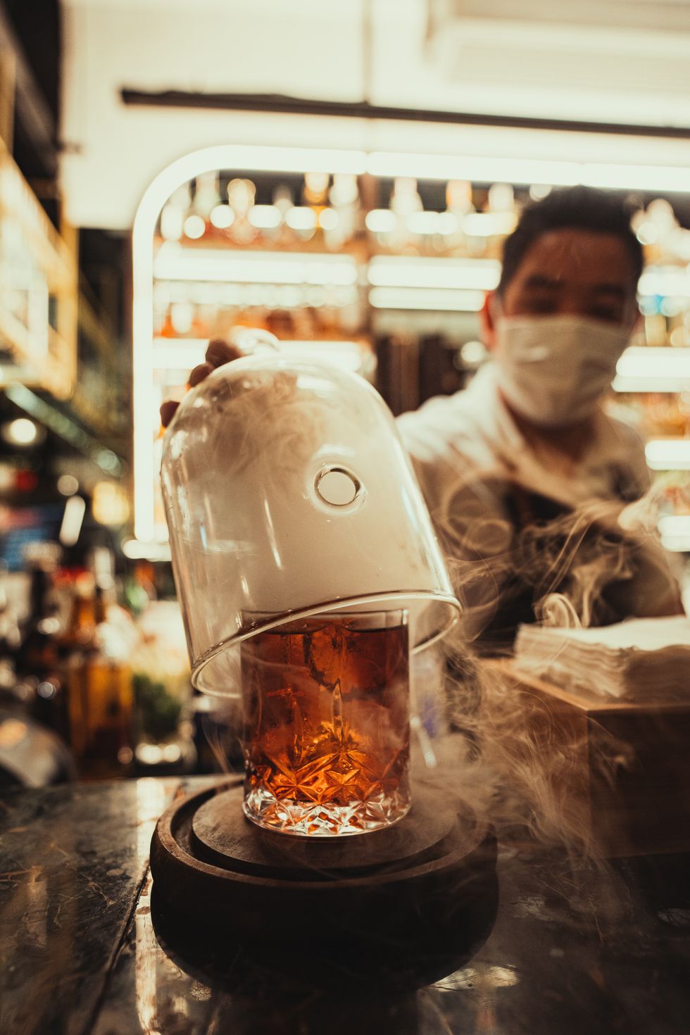 ​A waiter preparing a glass of Negroni.