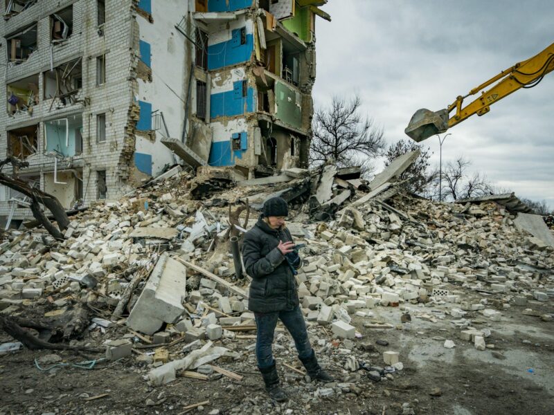 ​A woman checks in her phone the list of belongings recovered in the debris of her flat destroyed in the combats in Borodianka, Ukraine