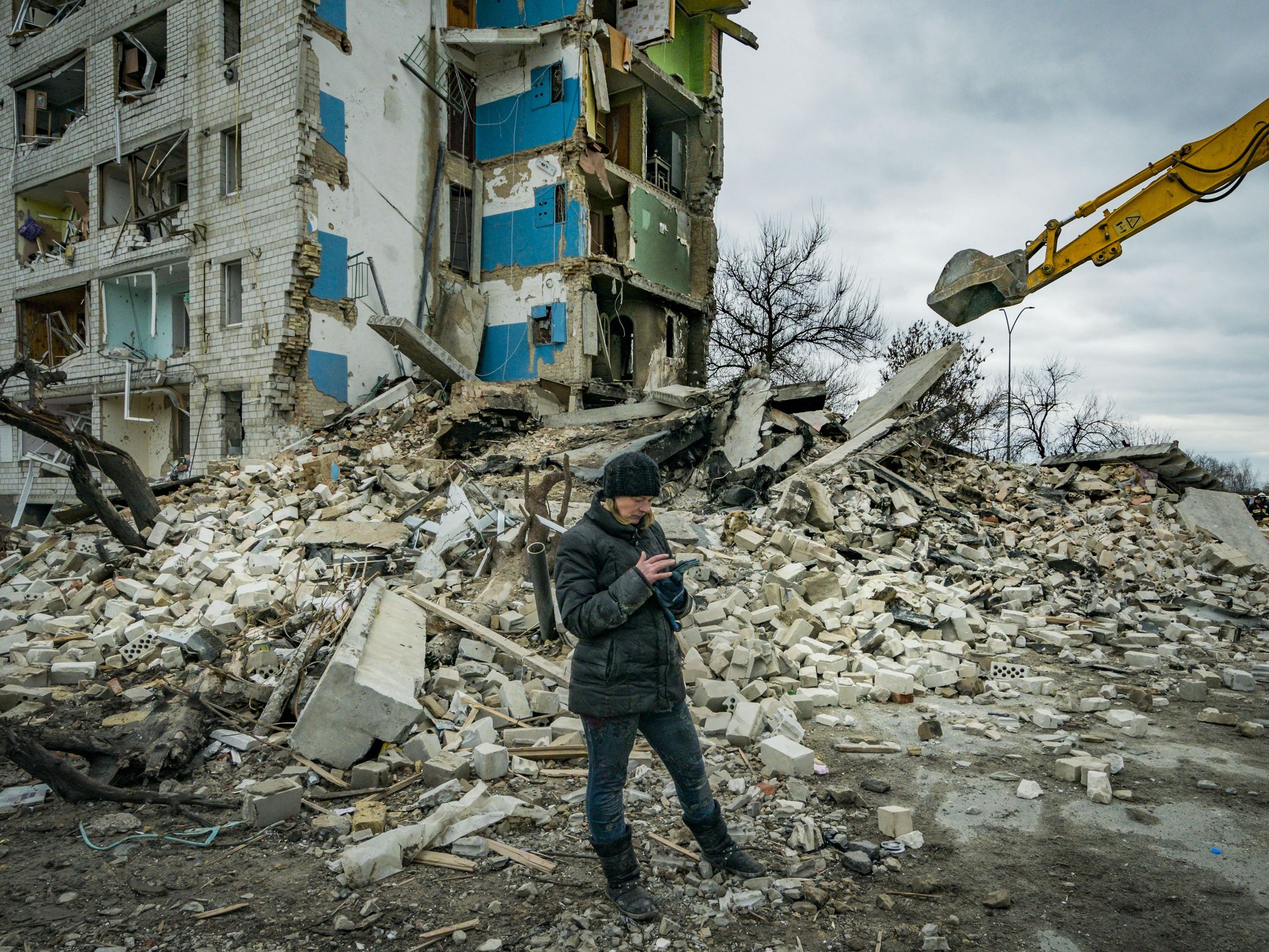 ​A woman checks in her phone the list of belongings recovered in the debris of her flat destroyed in the combats in Borodianka, Ukraine
