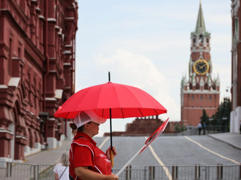 ​A woman holds a red umbrella in Moscow, Russia.