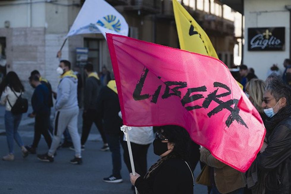 ​A woman seen holding an anti-mafia association Libera flag during a demonstration in Italy.
