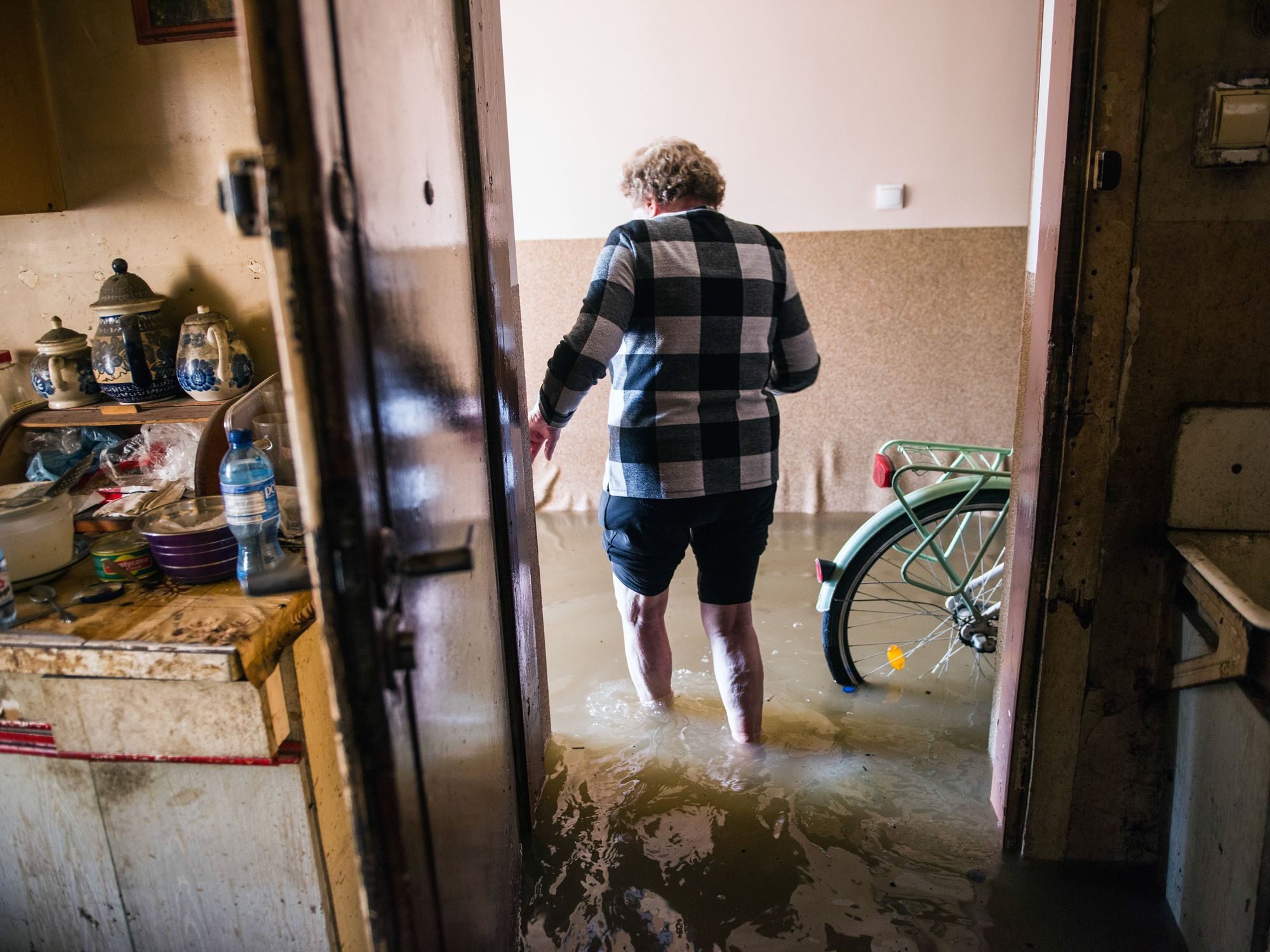 ​A woman stands in a flooded apartment in Lewin Brzeski in southern Poland.