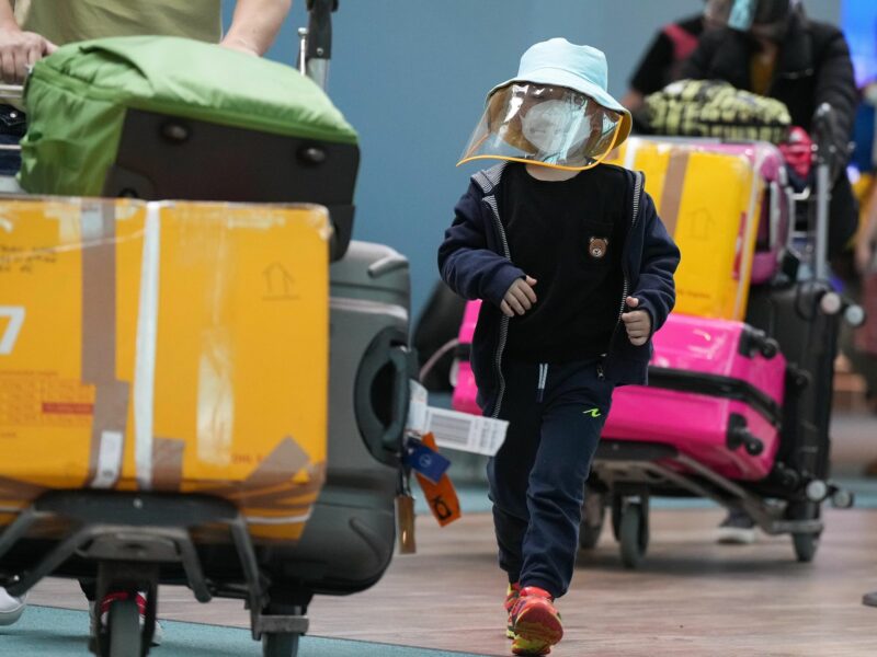 ​A young boy who arrived on a Cathay Pacific flight from Hong Kong wears a face mask and face shield at Vancouver International Airport in Canada on Jan. 10, 2023.