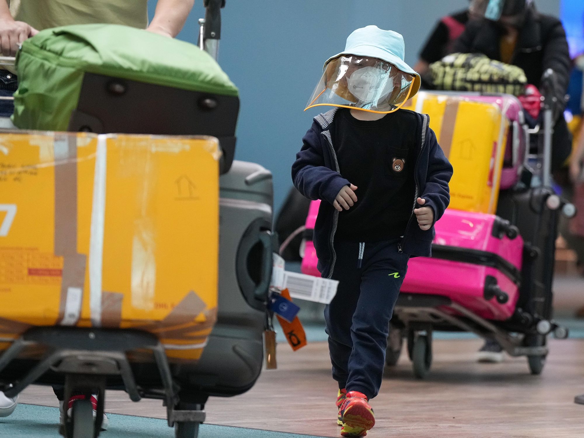 ​A young boy who arrived on a Cathay Pacific flight from Hong Kong wears a face mask and face shield at Vancouver International Airport in Canada on Jan. 10, 2023.