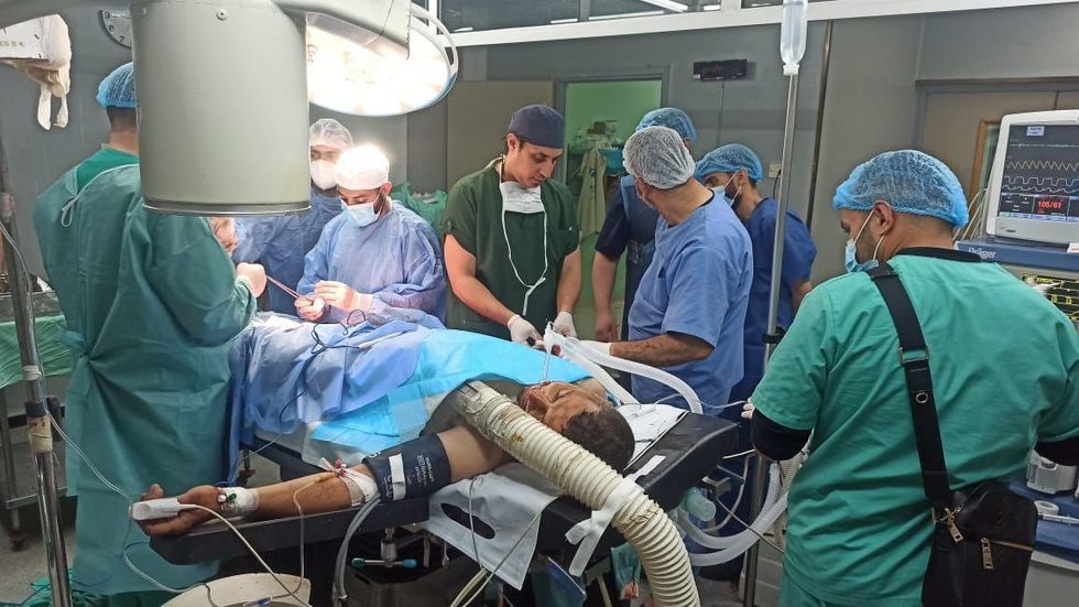 ​Abu Omar undergoing surgery after having a foot amputated. 8 doctors are in the room and Abu Omar is laying on the surgery tabel.