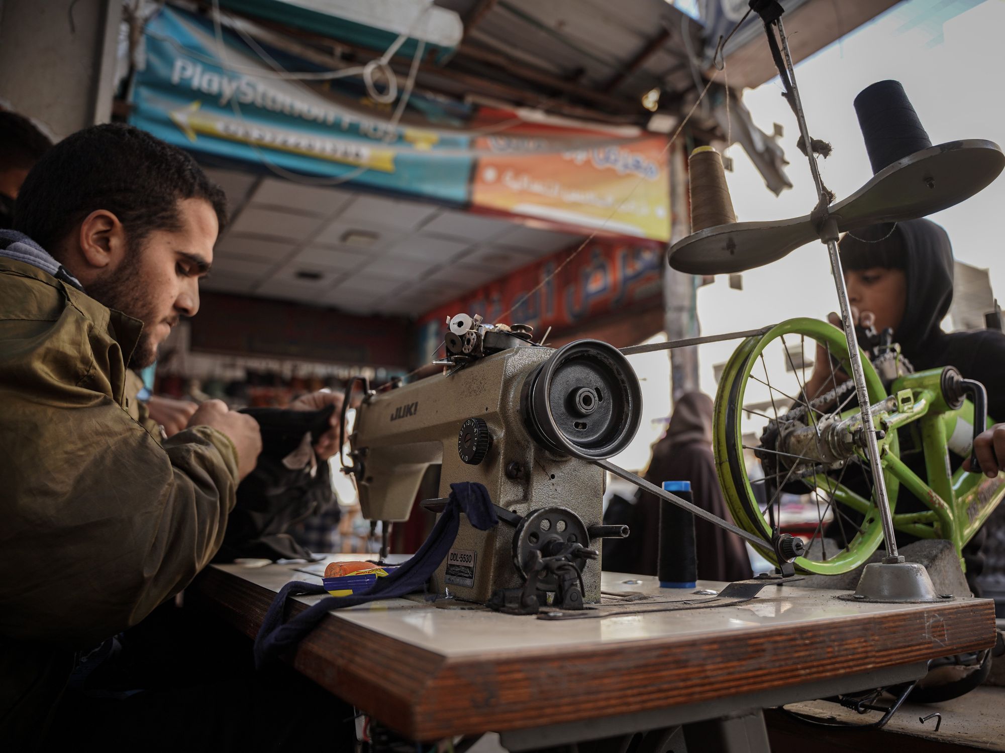 ​Amid power outage in Gaza, tailors use bicycle-powered sewing machine to repair things due to the lack of fuel and electricity.