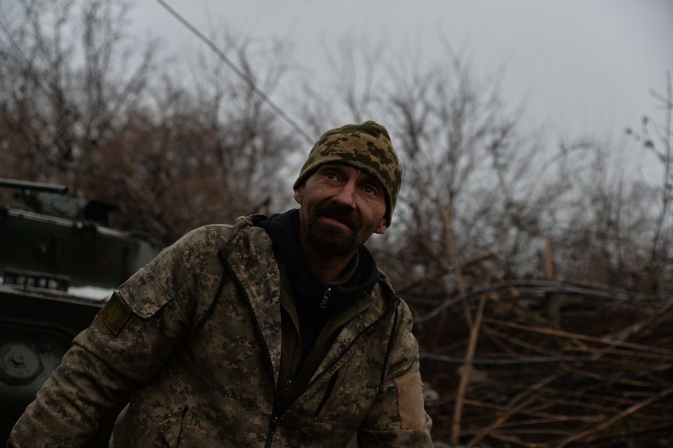 ​An older soldier poses in front of his BMP.