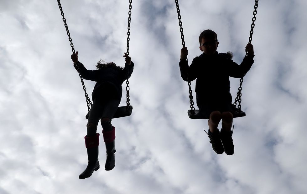 ​Children playing on swings in a park