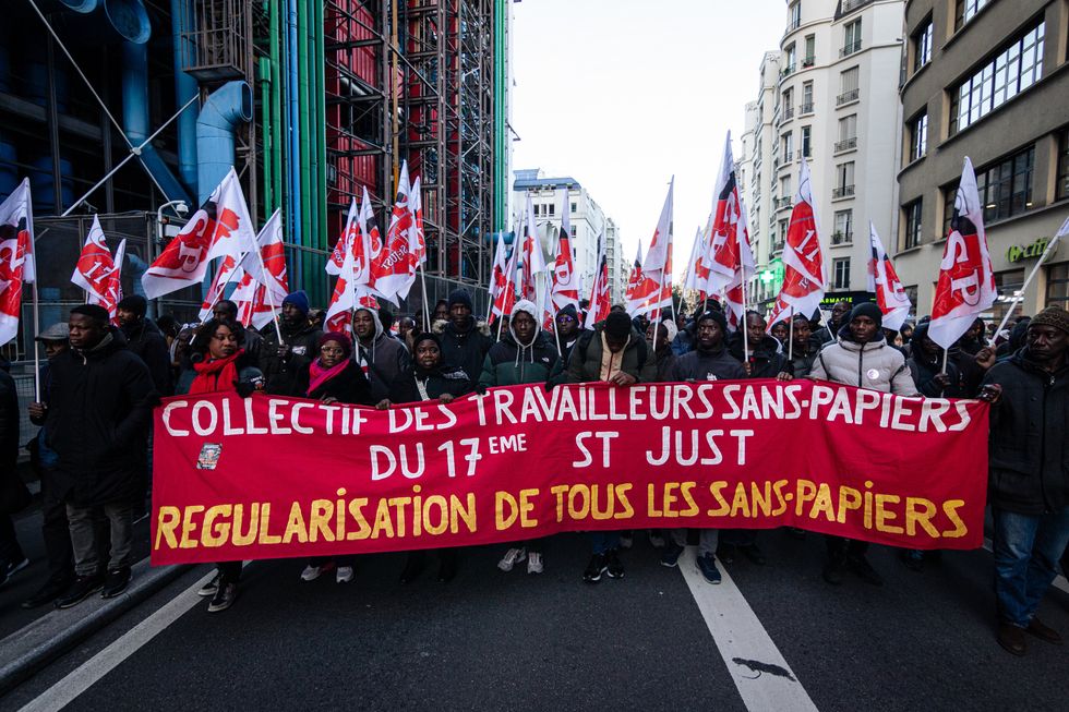 ​Collective of undocumented workers march during a demonstration in Paris.