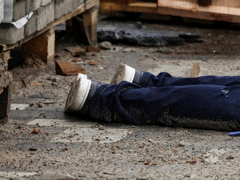 ​Detail of a photograph by AFP photographer Ronaldo Schemidt showing the legs of a body in the streets of Bucha, Ukraine