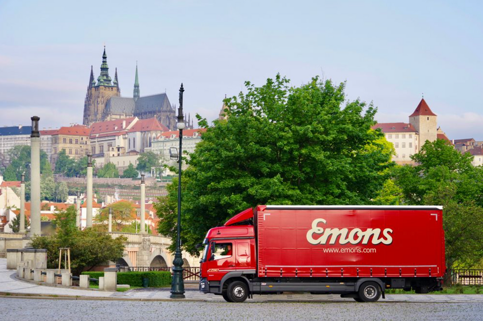 ​Emon trucker driving through European town.