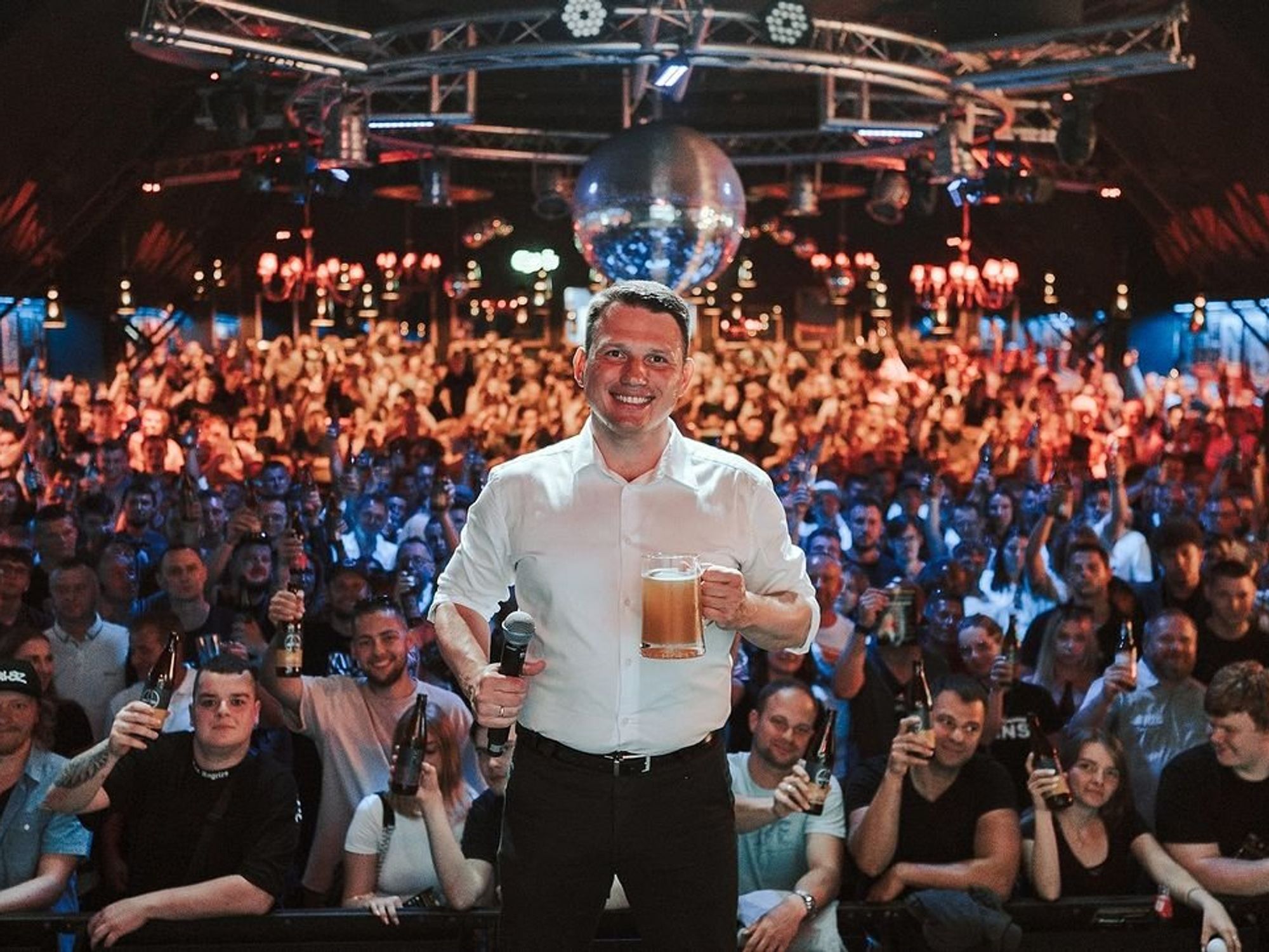​Far-right polish figure head Slawomir Mentzen posing with beer before a speech.​