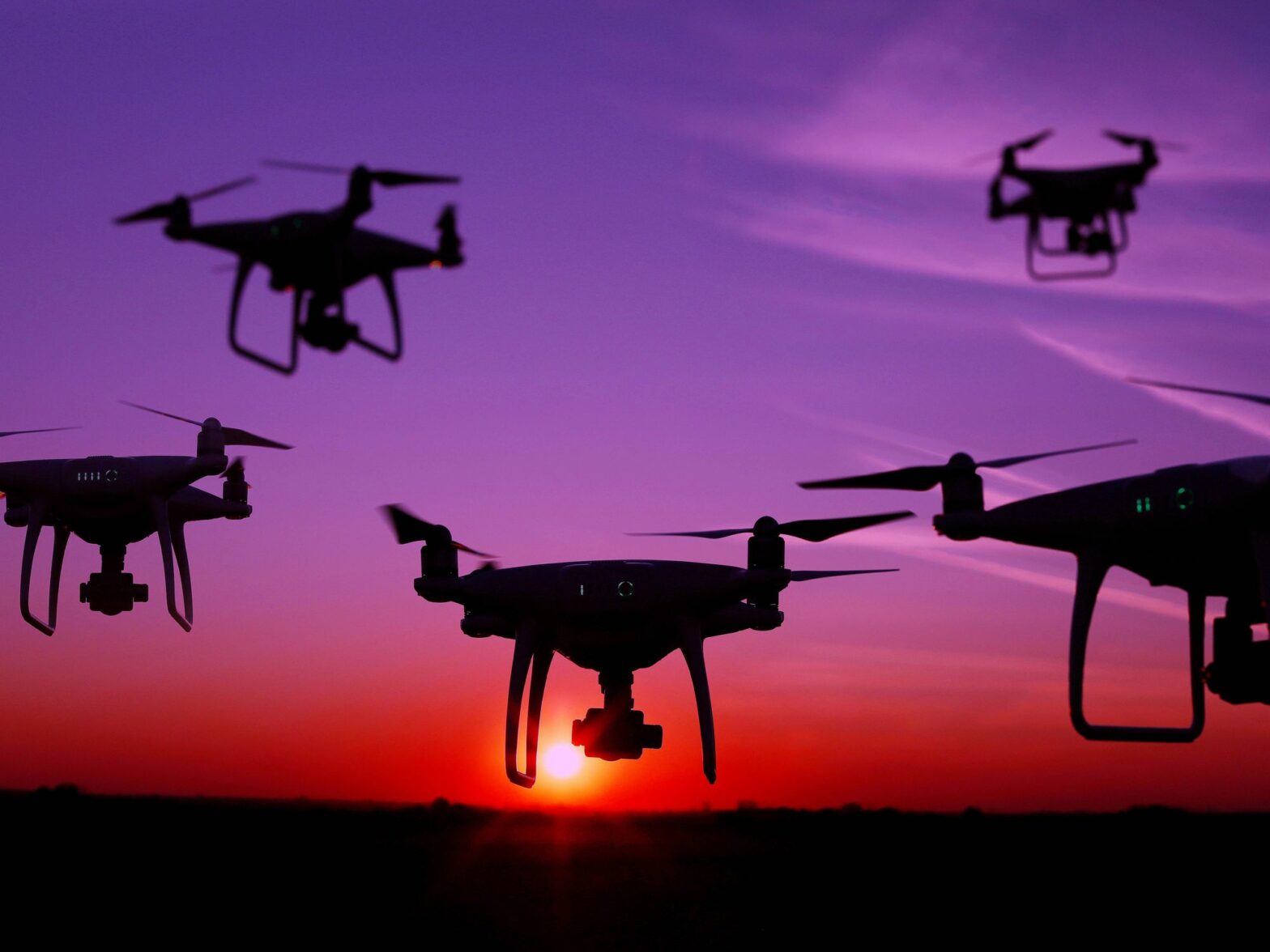 ​Five drones in the sky at sunset