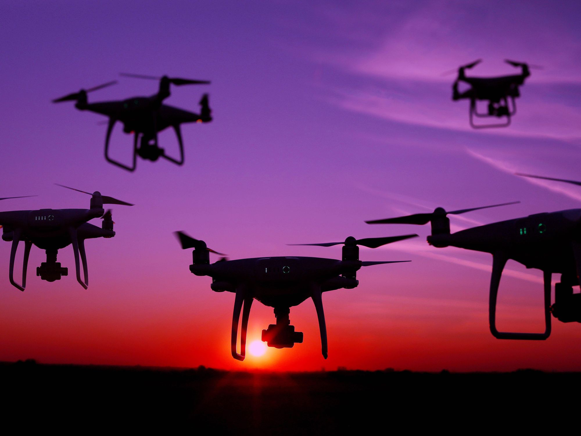 ​Five drones in the sky at sunset
