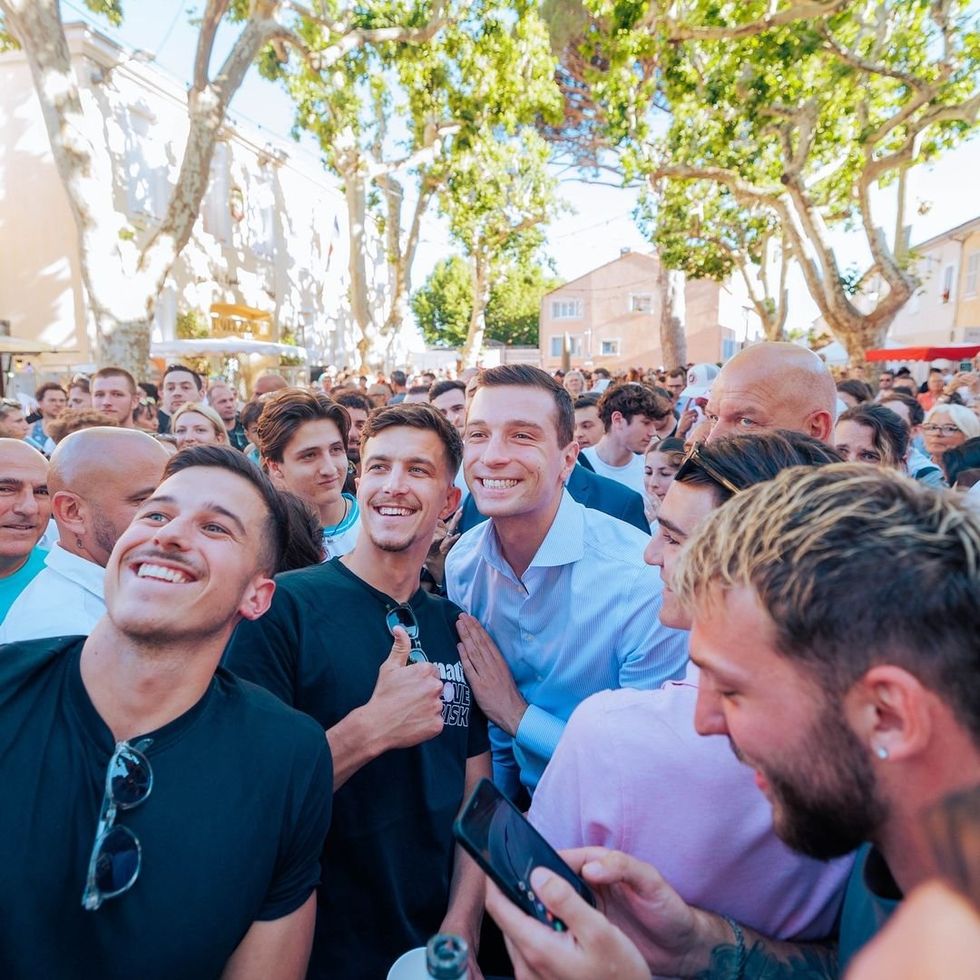 ​French Far-Right politican Jordan Bardella taking selfie with supporters.