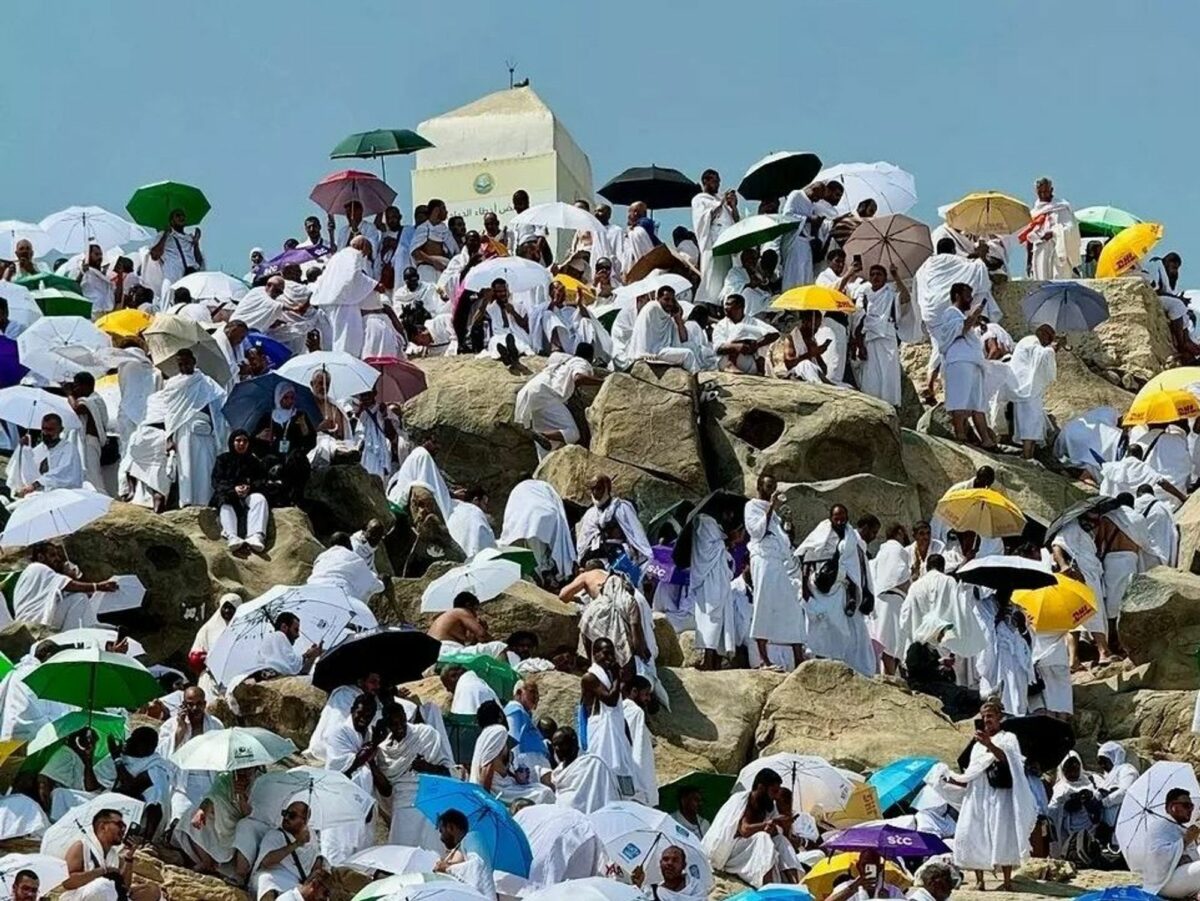 ​Hajj pilgrims crowd a hill with umbrellas to defend against the extreme heat.