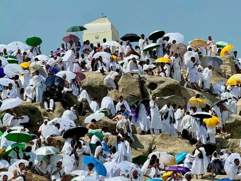 ​Hajj pilgrims crowd a hill with umbrellas to defend against the extreme heat.