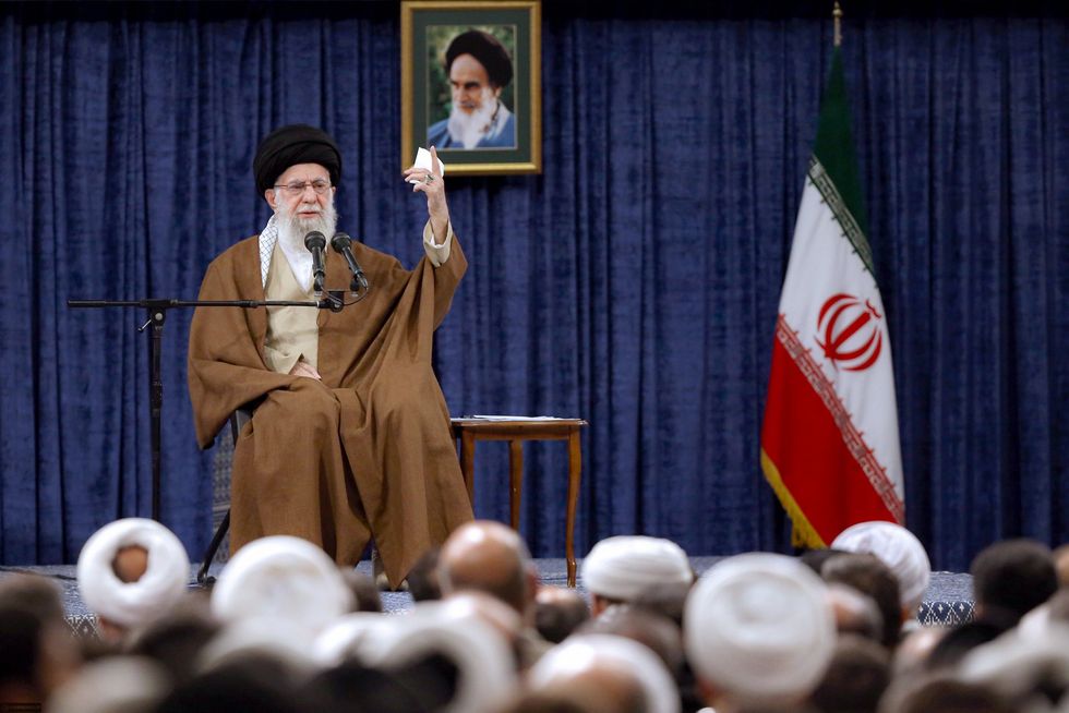 ​Iranian Supreme Leader Ayatollah Ali Khamenei speaking on stage with a crowd in front of him.