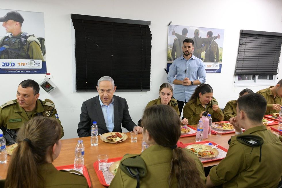 ​Israeli Prime Minister Benjamin Netanyahu seated at a conference table with IDF soldiers.