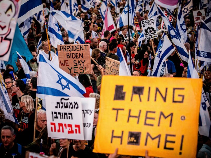 ​Israeli protestors hold placards during a demonstration.