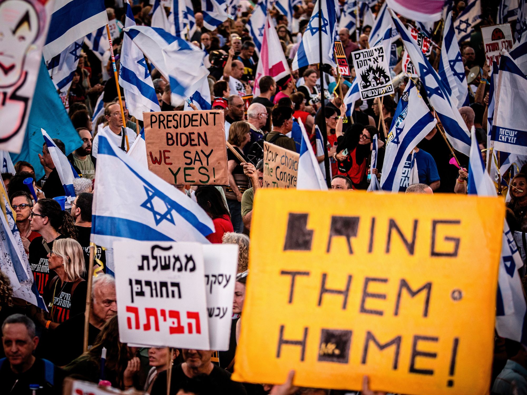​Israeli protestors hold placards during a demonstration.