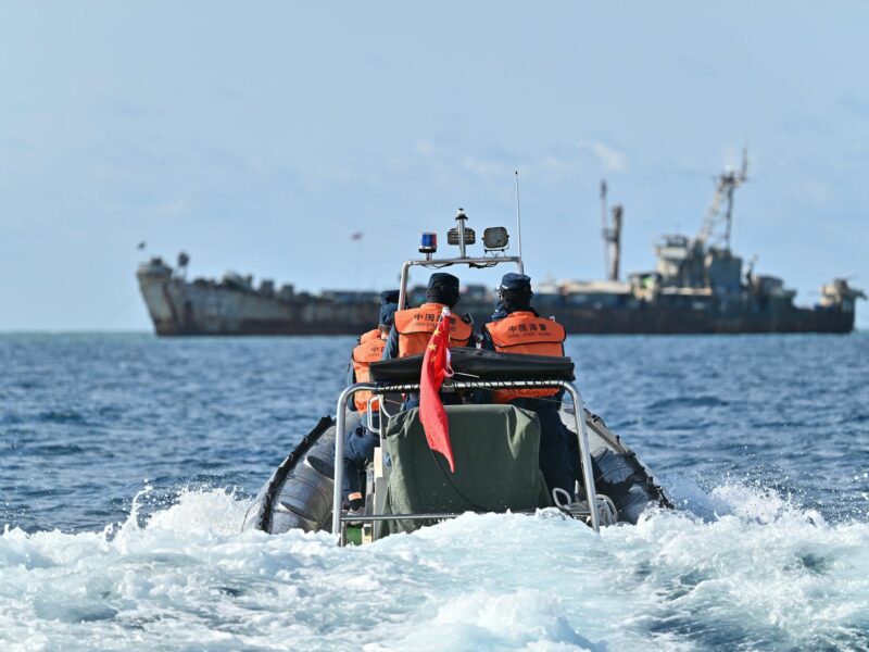​Law enforcers of China Coast Guard inspect near an illegally grounded Philippine navy transport ship.