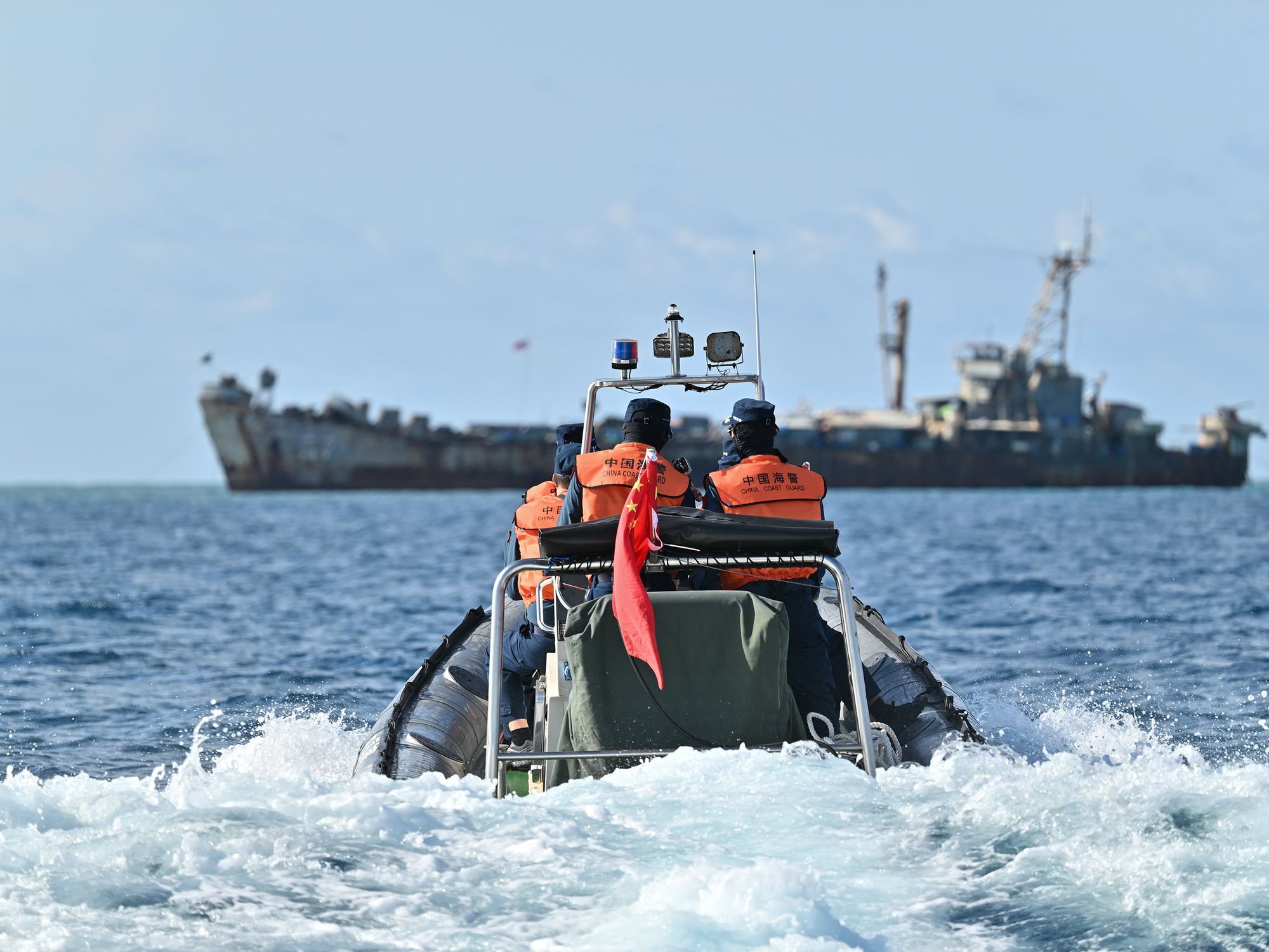 ​Law enforcers of China Coast Guard inspect near an illegally grounded Philippine navy transport ship.