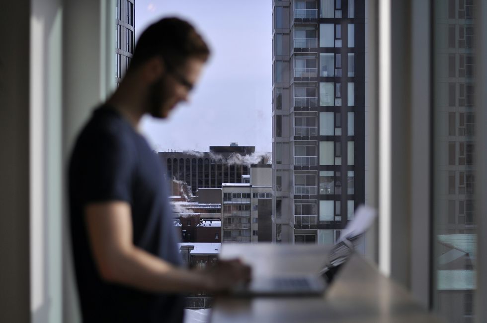​Man working in a city on his laptop.
