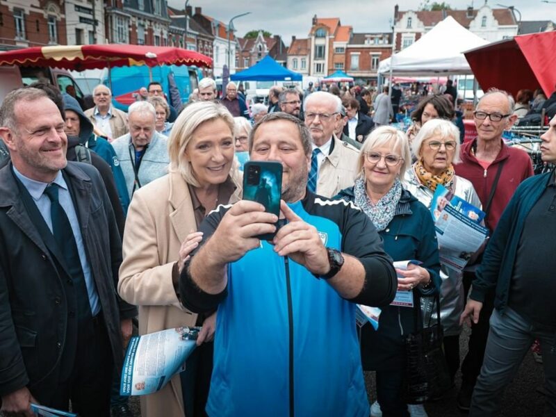 ​Marine Le Pen taking a picture with a fan.