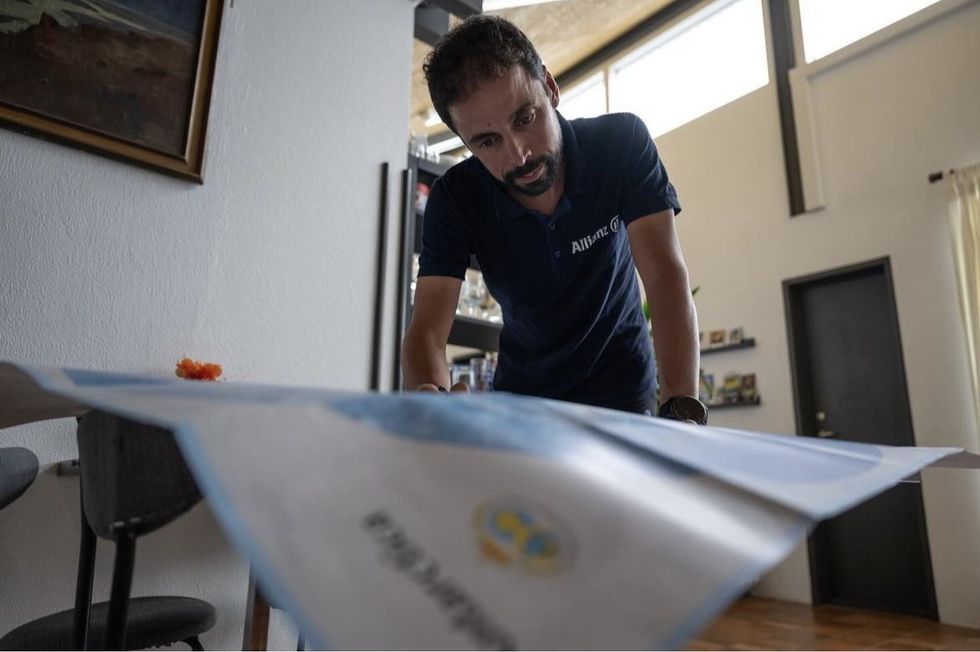 ​Omar Di Felice looking at a map of Antarctica