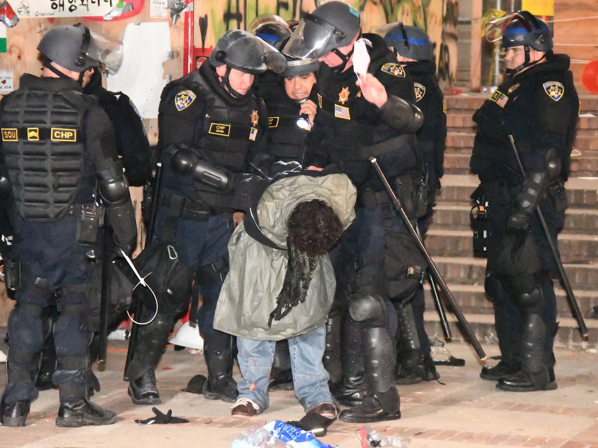 ​One of many arrests made by CHP officers in riot gear to take down a pro-Palestinian encampment on the UCLA campus.