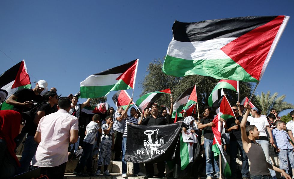 ​Palestinian protesters hold flags during a demonstration marking the 'Naksa Day' the annual day of commemoration for the Palestinian people of the displacement that accompanied Israel's victory in the 1967 Six-Day War, Jerusalem, June 5, 2012.