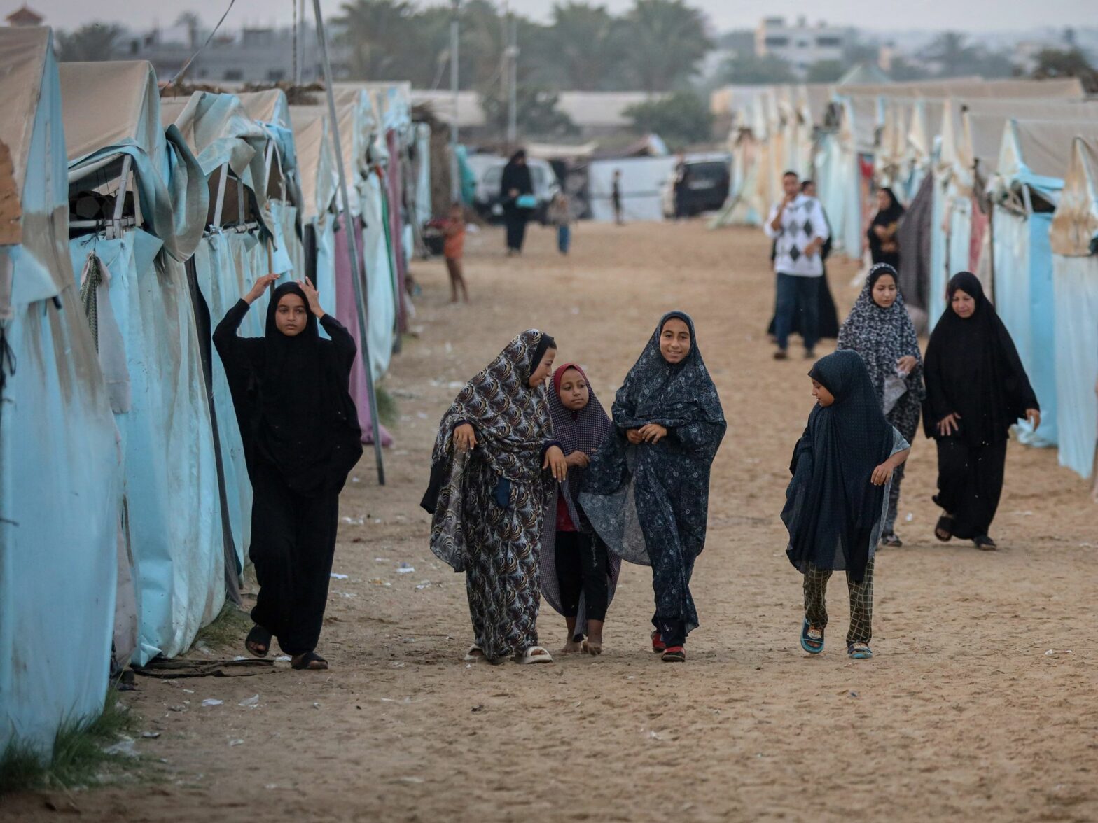 ​Palestinians hold Eid al-Adha prayers inside the camp to which they were displaced in Deir al-Balah in the central Gaza Strip.