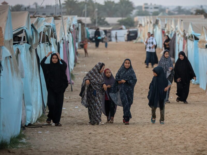 ​Palestinians hold Eid al-Adha prayers inside the camp to which they were displaced in Deir al-Balah in the central Gaza Strip.