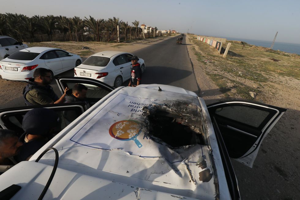 ​Palestinians inspect heavily damaged vehicles after Israeli attacks on aid organization World Central Kitchen.
