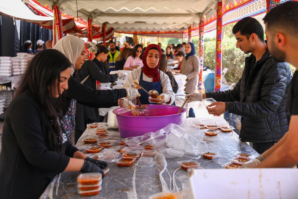 ​People prepare meals at a charity kitchen providing free food to fasting people during Ramadan.
