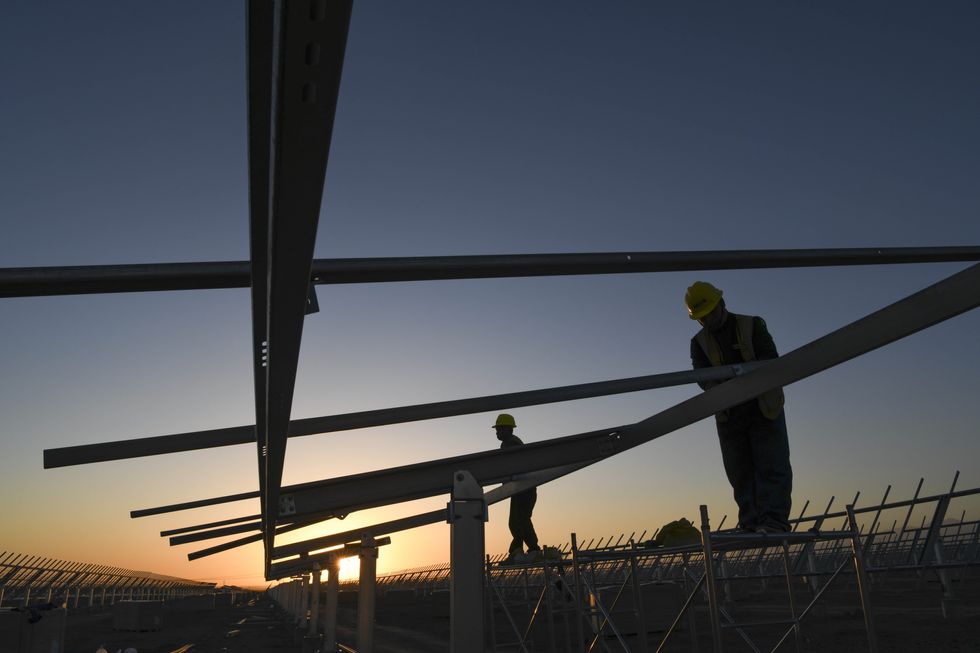 ​People work at the Shichengzi photovoltaic power station in Hami City, northwest China, September 2024.
