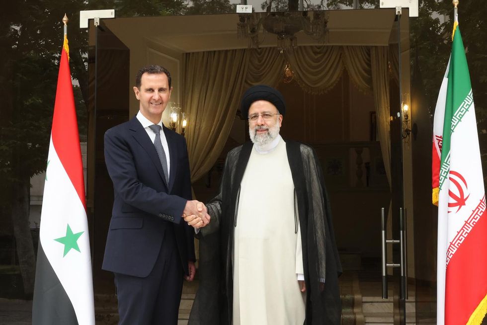 ​Photo of Iranian President Ebrahim Raisi shakes hand with Syrian President Bashar Al-Assad in the capital Tehran