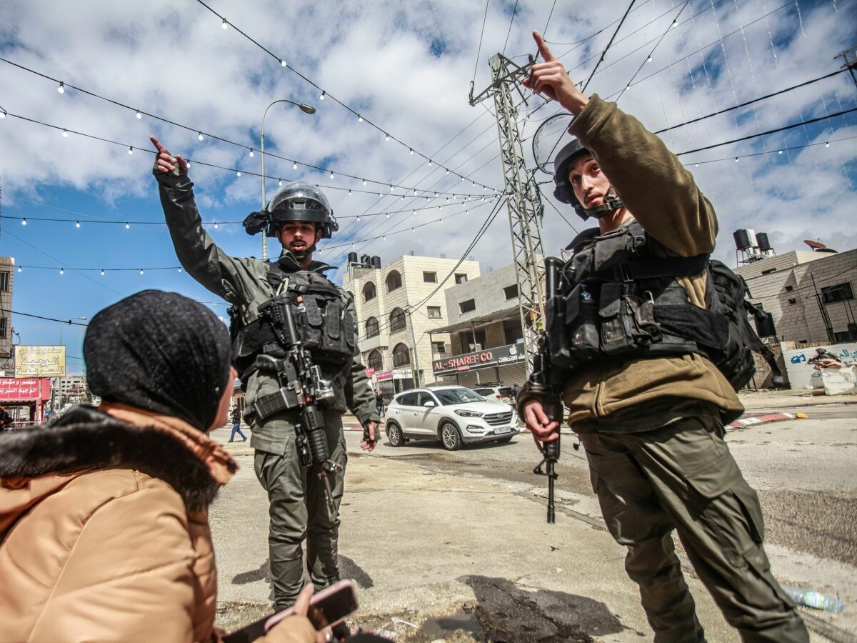 ​Photo of Israeli soldiers trying to chase away a Palestinian lady in the middle of the town of Hawara, after a shooting attack on a Jewish settler's car in the town, south of Nablus, in the occupied West Bank.