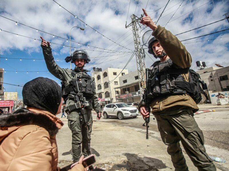 ​Photo of Israeli soldiers trying to chase away a Palestinian lady in the middle of the town of Hawara, after a shooting attack on a Jewish settler's car in the town, south of Nablus, in the occupied West Bank.