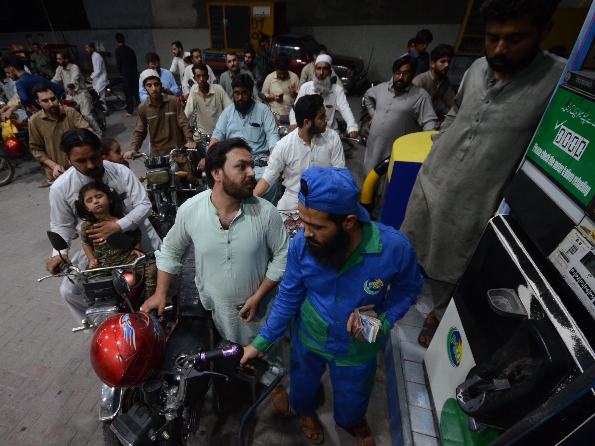 ​Photo of motorists wait to fill their vehicles' tanks at a petrol station